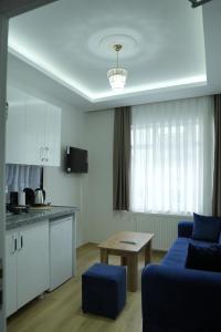a living room with a blue couch and a kitchen at BDK hotel in Istanbul