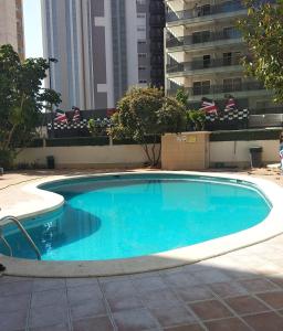 duży niebieski basen z budynkami w tle w obiekcie Apartamento Maysan IF Benidorm w mieście Benidorm