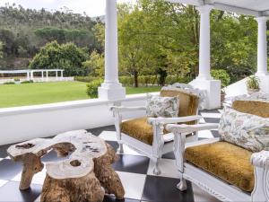a porch with two chairs and a teddy bear on it at Caledon Grace Guesthouse in Caledon
