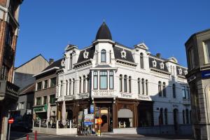un grande edificio bianco all'angolo di una strada di Hotel Grupello a Geraardsbergen