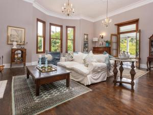 a living room with a white couch and a table at Caledon Grace Guesthouse in Caledon