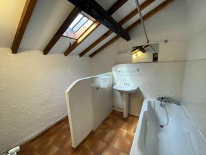 ein Badezimmer mit einer weißen Badewanne und einem Waschbecken in der Unterkunft Maison des Cévennes in Arphy + 36 Fotos