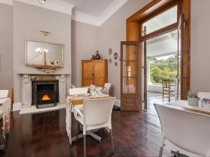 a dining room with a table and a fireplace at Caledon Grace Guesthouse in Caledon
