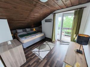 a bedroom with a bed and a large window at Panoráma Pelsó Apartman in Ábrahámhegy
