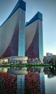 two tall buildings with reflections in a body of water at I LiKE ORBI CiTY in Angisa +40 photos