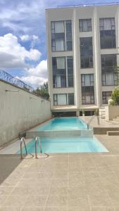 a swimming pool in front of a building at Tsavo apartment in Nairobi