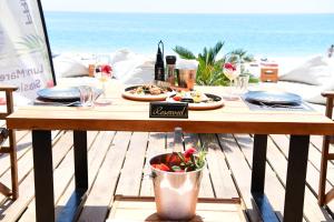 a table with plates of food on the beach at Luna Mare Boutique Seaside in Borsh