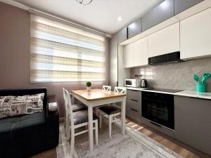 Una pequeña cocina con una mesa y un sofá. en Замечательная Раимбек резиденс 20-63 & питьевая вода подарок, en Almaty
