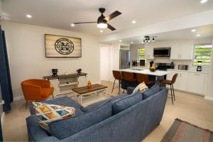 a living room with a blue couch and a kitchen at Xoop Homes - Ixora #1 in Saint Johnʼs