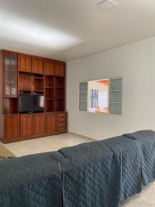 a bedroom with a bed and a cabinet and a microwave at Casa Jabuticabeira in Manhã
