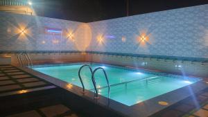 a swimming pool at night with lights in it at Bio Villas Resorts in Yelagiri +23 photos
