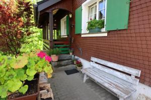 a wooden bench sitting outside of a house with flowers at Schwarzwaldhaus St Blasien, Direkt Am Bach in St. Blasien