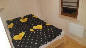 a bed with polka dot sheets on it in a room at Domek całoroczny in Buda Ruska