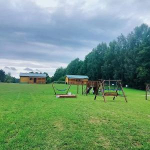 a playground with two swings in a field at Domek całoroczny in Buda Ruska