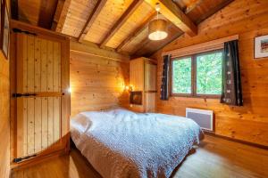 a bedroom in a log cabin with a bed at Proche de la Clusaz, Grand Chalet Familial, Ski & Nature in Saint-Jean-de-Sixt