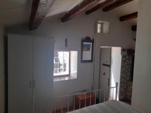 a kitchen with a white refrigerator and a window at Kapetanska kućica na moru in Cunski