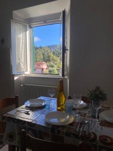 a table with plates and glasses and a window at CasinaAlice Montenero in Livorno