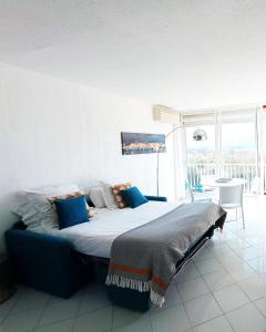 ein Schlafzimmer mit einem großen Bett und blauen Kissen in der Unterkunft studio cosy vue mer in Patrimonio