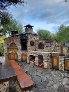 ein Außenofen mit einer Holzbank davor in der Unterkunft studio cosy vue mer in Patrimonio