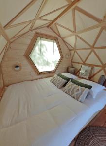 LanasCamping de l'arche Roulotte géodésique的有窗户的房间里有一张大床
