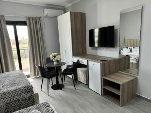 a living room with a room with a bed and a television at Hotel 4Palmat in Orikum