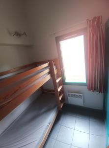 a room with a bunk bed and a window at Maisonnette Topaze bleu in Argelès-sur-Mer