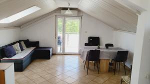 a living room with a table and a couch at Apratmani Maretic in Ugrinići