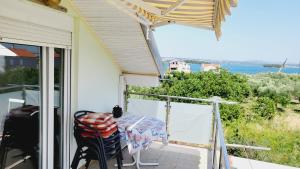 a balcony with a table and a view of the ocean at Apratmani Maretic in Ugrinići +9 photos