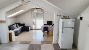 a living room with a couch and a refrigerator at Apratmani Maretic in Ugrinići
