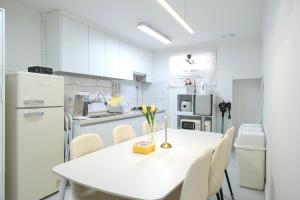 a white kitchen with a white table and chairs at busan in peum in Busan