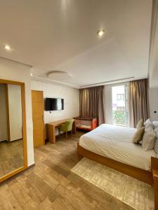 a hotel room with a bed and a desk at Hotel Residence Ramsis in Nador