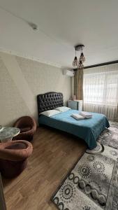 a bedroom with a bed and a couch and a rug at Гостиница Уютная in Kostanay