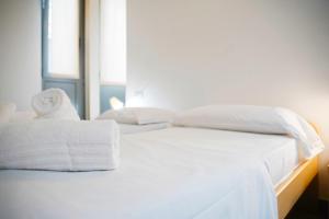 a white bed with white sheets and towels on it at Appartamento per famiglie, parcheggio di fronte WI FI grautito, self check in in Lecco