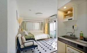 a small kitchen with a bed and a sink in a room at Komatsuya 小松屋民泊 京都梅田日本桥半小时内直达 in Osaka