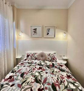 ein Schlafzimmer mit einem Bett und zwei Bildern an der Wand in der Unterkunft Apartamento incleibles vistas al océano y piscina. in Acantilado de los Gigantes