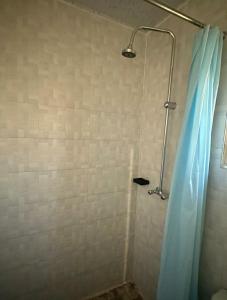 a shower with a blue shower curtain in a bathroom at EK Apartments in Lusaka