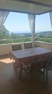 a table and chairs on a balcony with a view at Ribarićevi dvori in Banjol