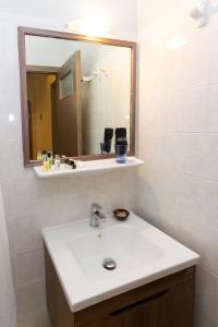 a bathroom with a sink and a mirror at G. Kiapekou in Loutra Edipsou +18 photos