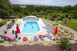 an outdoor swimming pool with chairs and umbrellas at Bretagne FeWo Menhir für 2 Personen, no Kids in Loperhet