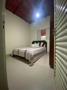 a bedroom with a bed in the corner of a room at Rancho Pé de Serra in Manhã