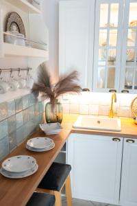 a kitchen with white cabinets and a wooden counter top at Hanga vendégház in Villány