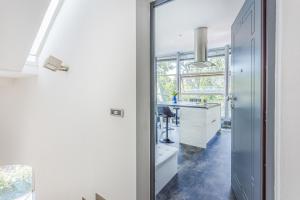 a kitchen with white cabinets and a desk at Comics & Cars - Themed Penthouse in Motor Valley in Modena