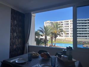 a dining room with a table and a large window at Sweet Holiday by luca properties grancanaria in Playa del Ingles
