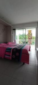 ein Schlafzimmer mit einem Bett und einem großen Fenster in der Unterkunft Location d Armelle - Moliets in Moliets-et-Maa