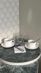 a table with plates and wine glasses on it at Гостиница Уютная in Kostanay