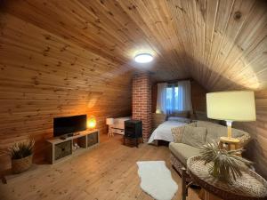 a living room with a couch and a bed in a cabin at Līči in Alūksne