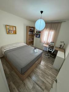 a bedroom with a large bed and a desk at Lucia Guest House Beach - apartamento Family, Friends & Fun PET FRIENDLY in Málaga