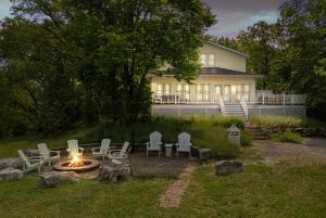 ein Hinterhof mit Feuerstelle und Stühlen und ein Haus in der Unterkunft Coastal Cottage in Stevensville