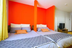 a bedroom with a large bed with an orange wall at Rambler 202 in Sapporo