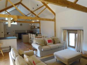 a living room with two couches and a kitchen at Yondhill Barn in Okehampton